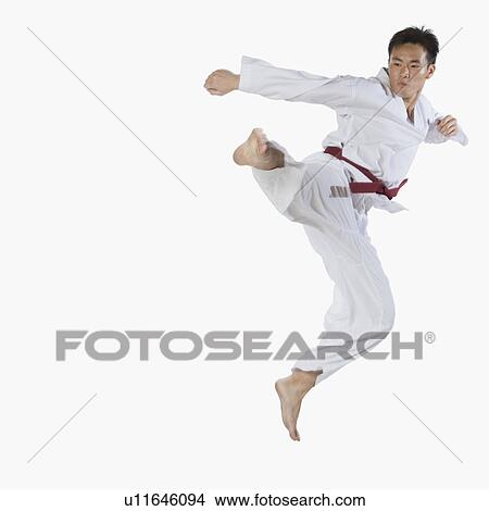 Close-up of a young man jumping and practicing martial arts View Large Photo Image Picture - Close-up of a young man jumping and practicing martial arts. Fotosearch