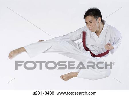 Close-up of a young man jumping and practicing martial arts View Large Photo Image Stock Photo - Close-up of a young man jumping and practicing martial arts. Fotosearch