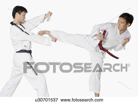 Stock Photo - Mid adult man practicing kickboxing with a young man. Fotosearch