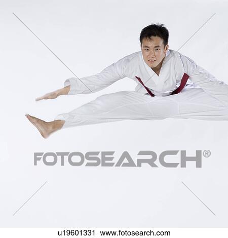 Portrait of a young man jumping and practicing martial arts View Large Photo Image Stock Image - Portrait of a young man jumping and practicing martial arts. Fotosearch