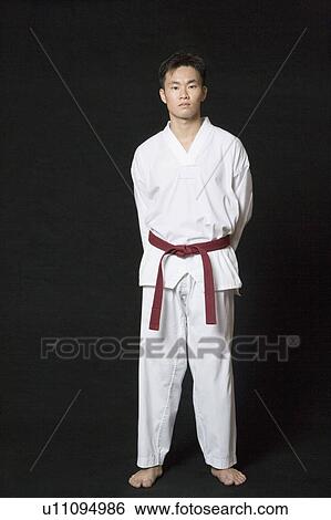 Stock Photograph - Portrait of a young man standing in gi. Fotosearch