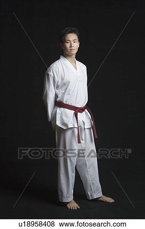 Portrait of a young man standing with his hands behind his back View Large Photo Image Stock Photo - Portrait of a young man standing with his hands behind his back. Fotosearch
