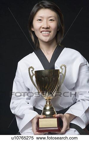 Portrait of a young woman holding a trophy View Large Photo Image Stock Photography - Portrait of a young woman holding a trophy. Fotosearch