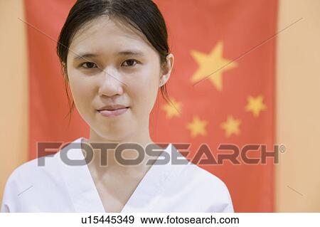 Stock Photo - Portrait of a young woman with a Chinese flag in the background. Fotosearch