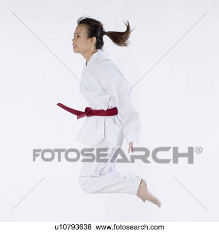Side profile of a young woman jumping and practicing martial arts View Large Photo Image Stock Photo - Side profile of a young woman jumping and practicing martial arts. Fotosearch