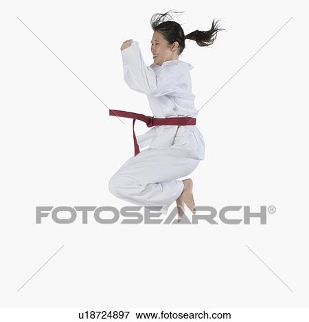 Side profile of a young woman jumping and practicing martial arts View Large Photo Image Stock Photo - Side profile of a young woman jumping and practicing martial arts. Fotosearch
