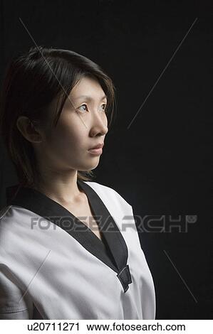 Stock Image - Side profile of a young woman contemplating in gi. Fotosearch