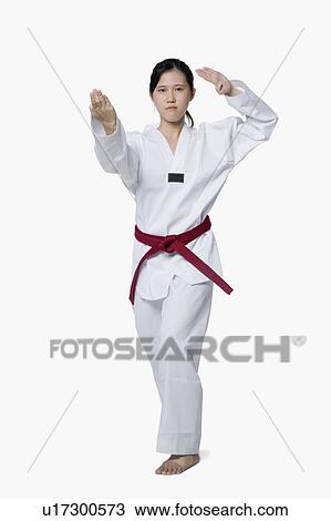 Stock Image - Young woman practicing karate. Fotosearch