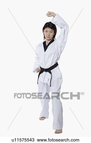 Stock Image - Young woman practicing upper block. Fotosearch