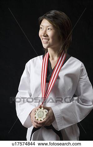 Young woman standing with a medal around her neck View Large Photo Image Picture - Young woman standing with a medal around her neck. Fotosearch