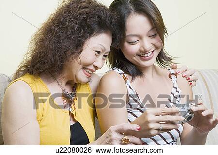 Close-up of a senior woman and her granddaughter looking photographs in a digital camera View Large Photo Image Stock Photograph - Close-up of a senior woman and her granddaughter looking photographs in a digital camera. Fotosearch