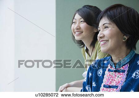 Stock Image - Close-up of a senior woman smiling with her granddaughter. Fotosearch