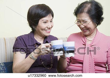 Close-up of two senior women toasting with cups and smiling View Large Photo Image Stock Image - Close-up of two senior women toasting with cups and smiling. Fotosearch