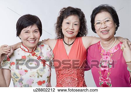Stock Image - Portrait of three senior women standing together and smiling. Fotosearch