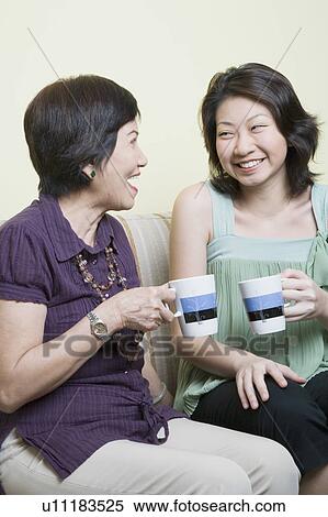 Senior woman and her granddaughter holding cups and smiling View Large Photo Image Stock Photography - Senior woman and her granddaughter holding cups and smiling. Fotosearch