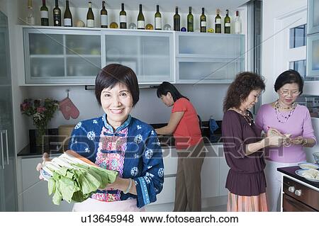 Three senior women and a mature woman preparing food in a domestic kitchen View Large Photo Image Stock Photo - Three senior women and a mature woman preparing food in a domestic kitchen. Fotosearch