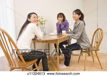 Three young women chatting at coffee table View Large Photo Image Stock Image - Three young women chatting at coffee table. Fotosearch
