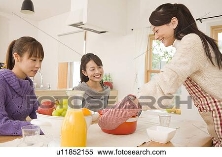 Three young women chatting at dinning table View Large Photo Image Stock Photography - Three young women chatting at dinning table. Fotosearch