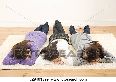 Three young women lying on floor View Large Photo Image Stock Photo - Three young women lying on floor. Fotosearch