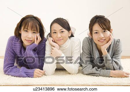 Three young women lying on floor View Large Photo Image Stock Photograph - Three young women lying on floor. Fotosearch