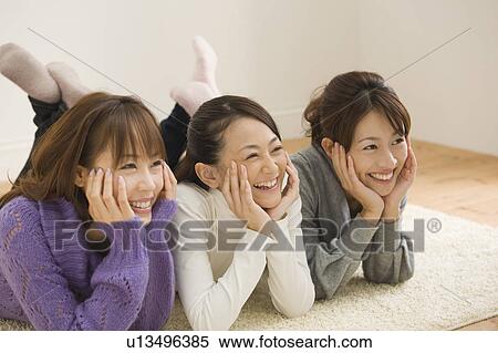 Three young women lying on floor View Large Photo Image Stock Photography - Three young women lying on floor. Fotosearch