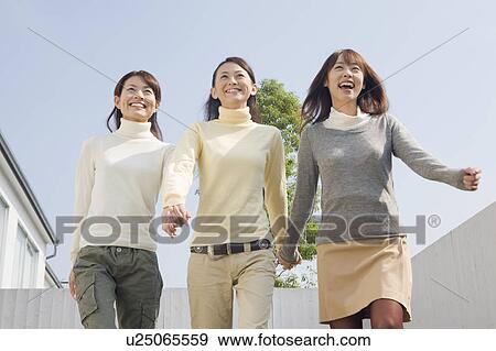 Three young women walking front yard View Large Photo Image Stock Photo - Three young women walking front yard. Fotosearch