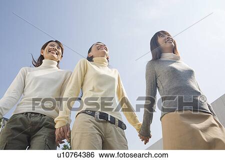 Three young women walking front yard View Large Photo Image Stock Photograph - Three young women walking front yard. Fotosearch