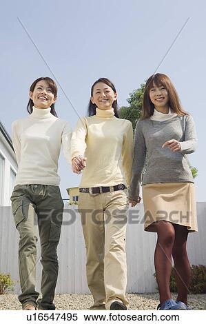 Three young women walking front yard View Large Photo Image Stock Photography - Three young women walking front yard. Fotosearch