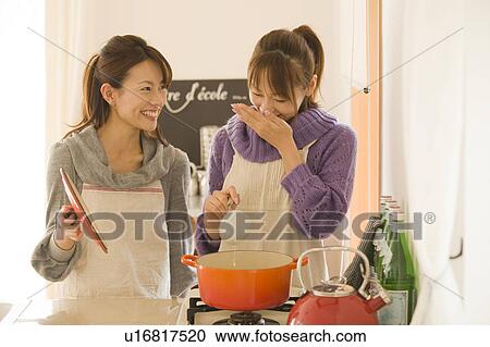 Two young women cooking in kitchen View Large Photo Image Stock Image - Two young women cooking in kitchen . Fotosearch