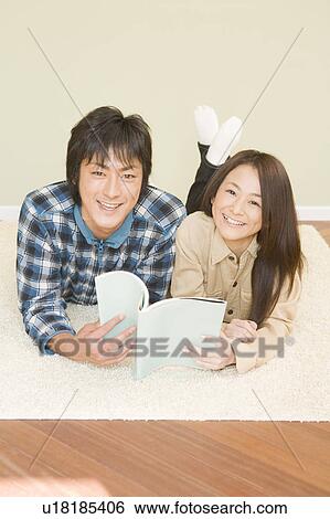 Stock Photograph - Young couple reading book. Fotosearch