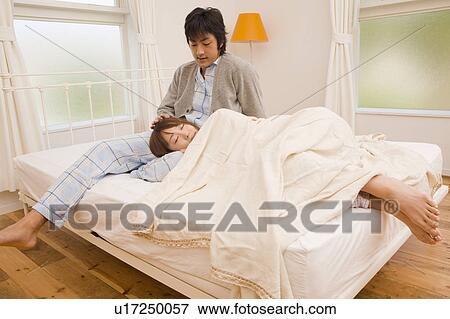 Stock Photo - Young couple relaxing on bed. Fotosearch