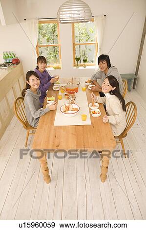 Stock Photo - Young man and young women having home party. Fotosearch