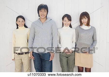 Young people standing in front of wall View Large Photo Image Stock Image - Young people standing in front of wall. Fotosearch
