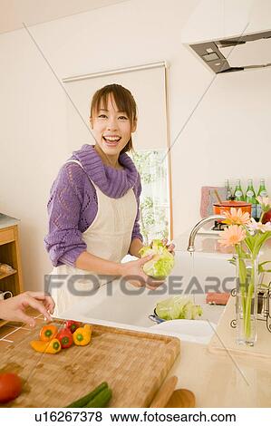 Young woman cooking in kitchen View Large Photo Image Stock Photo - Young woman cooking in kitchen. Fotosearch