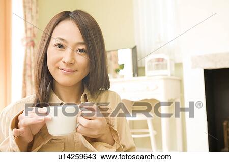 Young woman holding cup View Large Photo Image Stock Image - Young woman holding cup. Fotosearch
