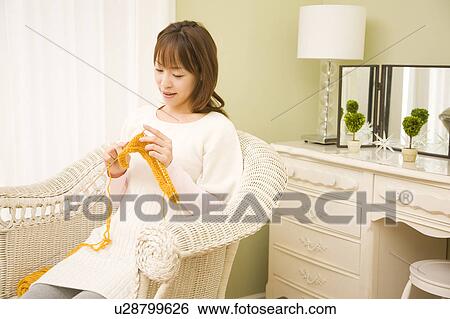 Stock Photograph - Young woman knitting on chair. Fotosearch