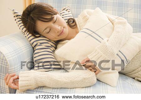 Stock Photograph - Young woman lying on sofa. Fotosearch