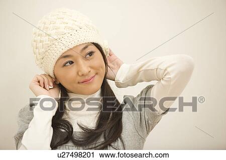 Stock Image - Young woman wearing cap. Fotosearch