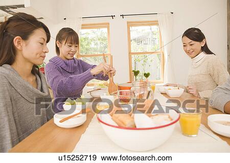 Stock Photo - Young women having home party. Fotosearch