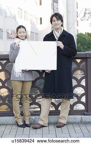 Picture - Businessman and businesswoman holding blank board. Fotosearch