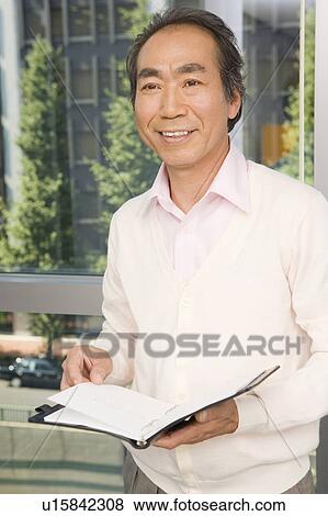 Businessman holding notebook View Large Photo Image Stock Photo - Businessman holding notebook. Fotosearch