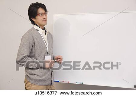 Businessman standing in front of board View Large Photo Image Stock Photo - Businessman standing in front of board. Fotosearch