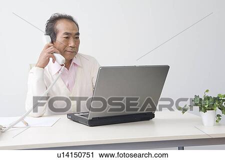 Stock Image - Businessman working in office. Fotosearch