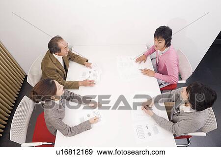 Four people discussing in meeting room View Large Photo Image Stock Photo - Four people discussing in meeting room. Fotosearch