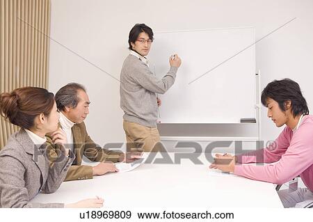 Stock Photo - Four people discussing in meeting room. Fotosearch