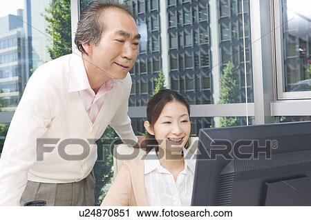 Mature man and young woman working in office View Large Photo Image Stock Image - Mature man and young woman working in office. Fotosearch