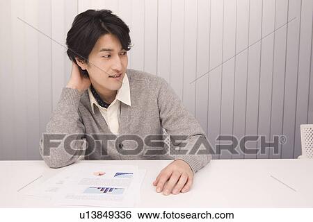 Stock Photograph - Mid adult man working in office. Fotosearch