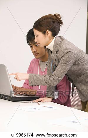 Picture - Young man and young woman working in office. Fotosearch