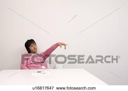Stock Photo - Young man flying paper airplane. Fotosearch