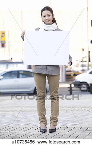 Young woman holding blank board View Large Photo Image Stock Photograph - Young woman holding blank board. Fotosearch